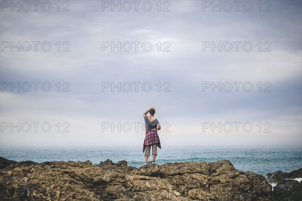 Australia, New South Wales, Woman standing on cliff and looking at view