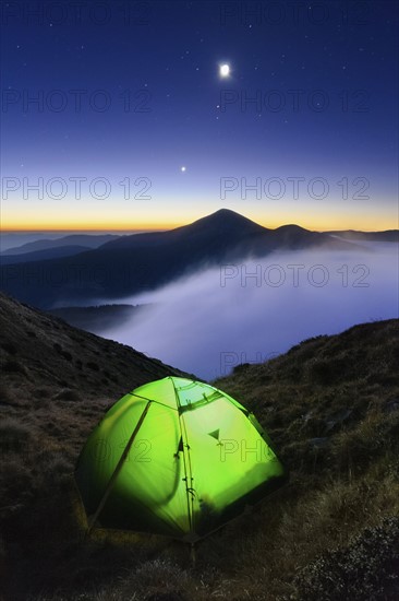 Ukraine, Zakarpattia region, Rakhiv district, Carpathians, Chornohora, Tent on mountain meadow at dusk