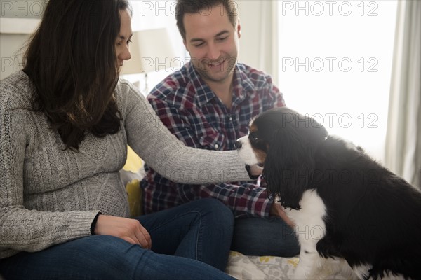 Mid adult couple relaxing with puppy