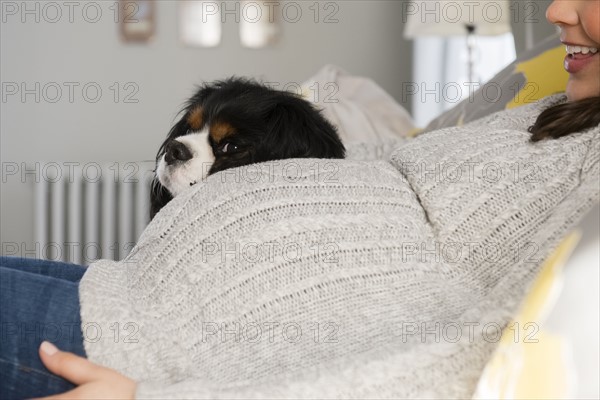 Side view of pregnant woman relaxing next to dog