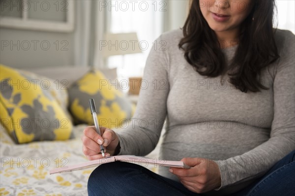 Pregnant woman writing journal