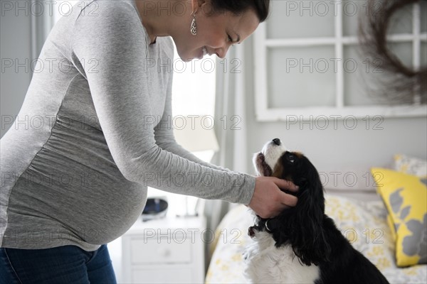 Pregnant woman looking at dog