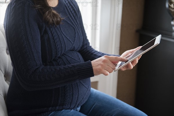 Pregnant woman using digital tablet
