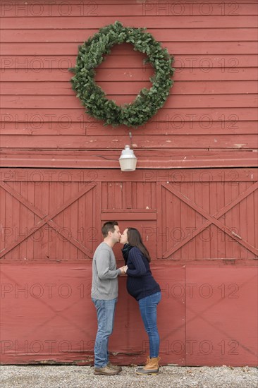 Couple kissing below wreath
