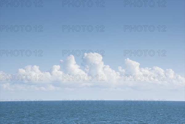 White cumulus clouds above blue Atlantic Ocean