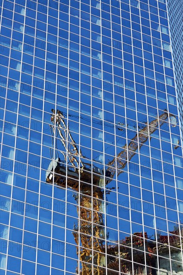 USA, New York, New York City, Crane reflecting in glass wall