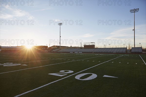 Forty yard line on green playing field at sunset