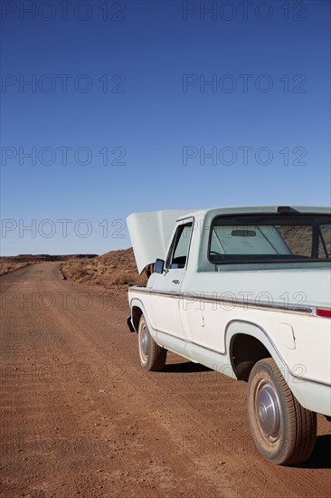 USA, Arizona, Broken pick up truck parked on desert road