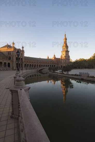 Spain, Andalusia, Seville, Tower in Plaza de Espana reflected in water