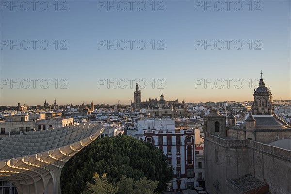 Spain, Andalusia, Seville, Cityscape in sunlight at dusk seen from Metropol Parasol in Plaza de Encarnacion
