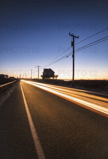 Blurred headlight of car on road at dawn