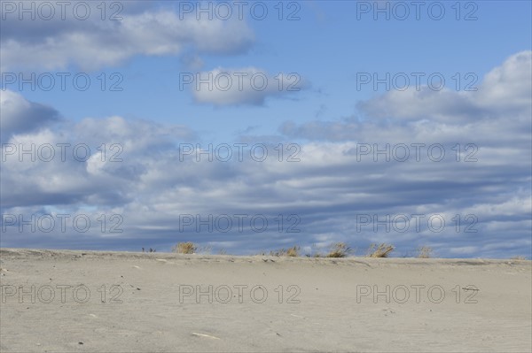 Clouds over sand dunes on beach