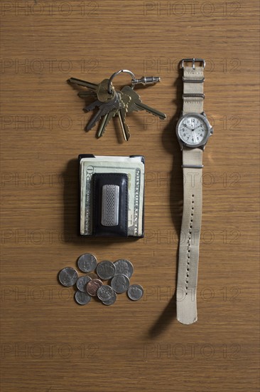 Watch, keys and money on table