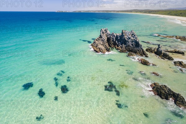 Australia, New South Wales, Bermagui, Turquoise sea with rock formation and coastline in background
