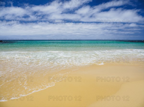 White clouds above sea and sandy beach