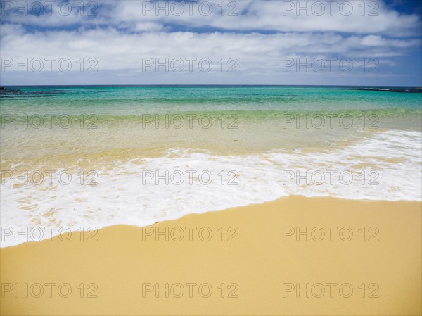 White clouds above sea and sandy beach