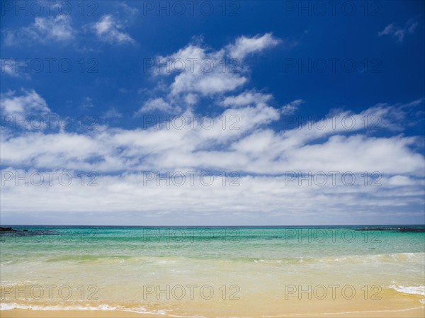 White clouds above sea and sandy beach