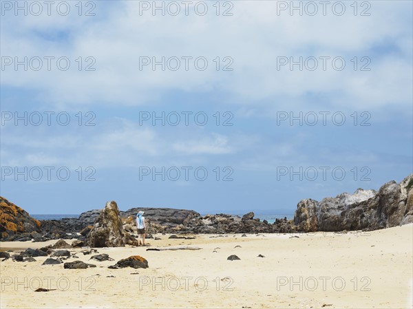 Australia, New South Wales, Bermagui, Woman walking along sandy beach