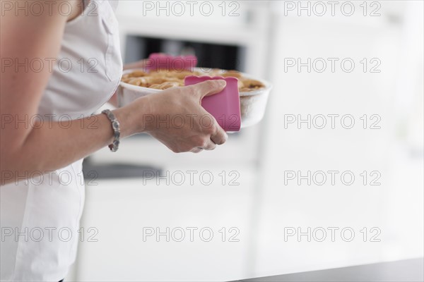 Woman holding hot casserole dish