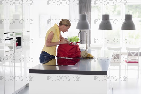 Woman unpacking groceries from shopping bag