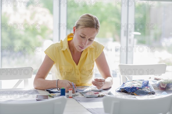 Woman making quilt