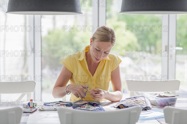 Woman making quilt