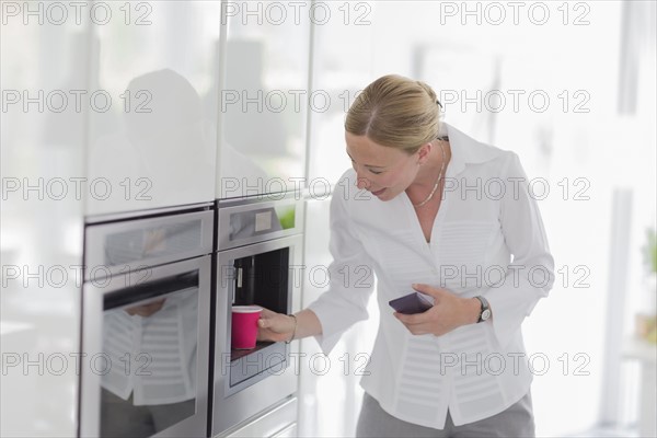 Woman making coffee in kitchen