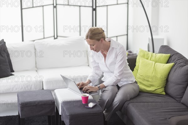 Woman using laptop in living room