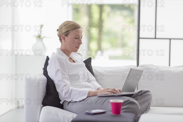 Woman using laptop in living room