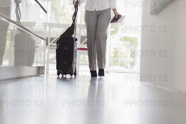 Businesswoman walking with suitcase