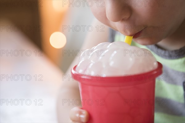 Boy blowing bubbles in drink