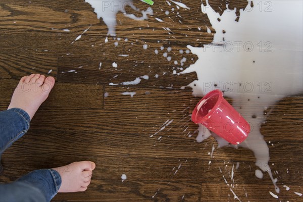 Boy's feet by spilt milkshake