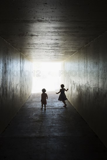 Silhouettes of children in tunnel