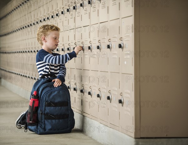 Boy with backpack by school lockers