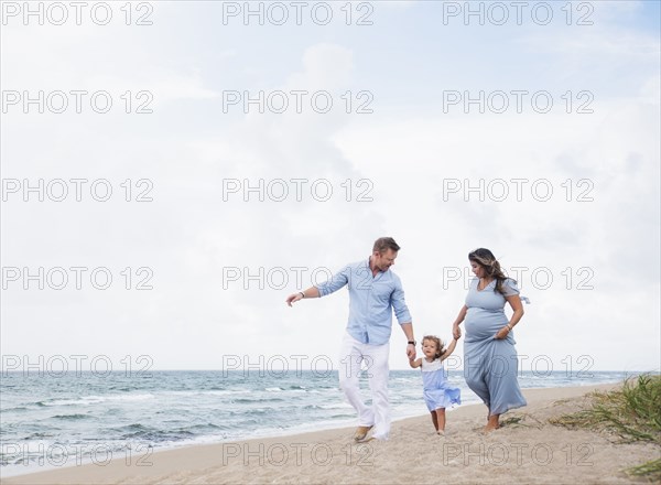 Family holding hands on beach