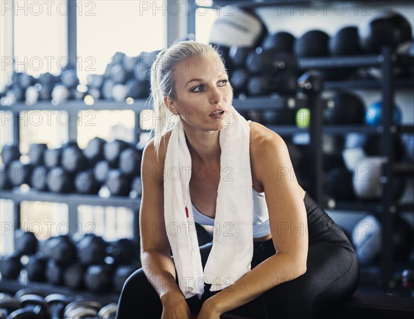 Young woman with towel in gym