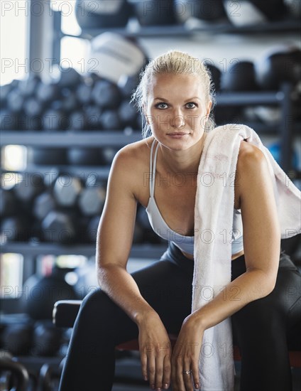 Portrait of young woman with towel in gym