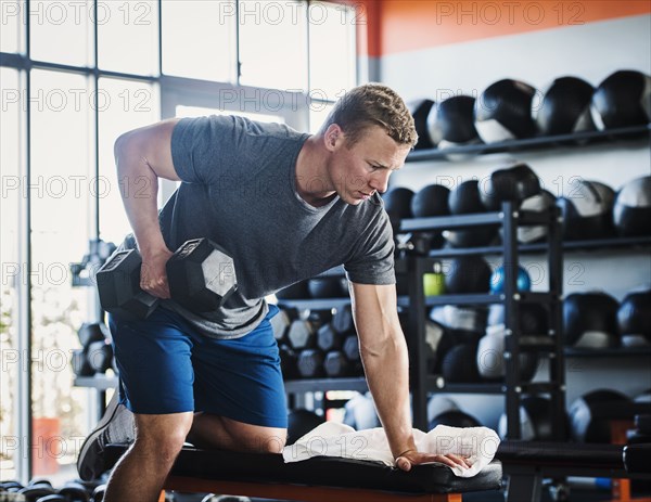 Mid adult man weight lifting