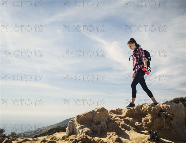 Woman hiking over rocks