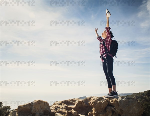 Woman on hike with arms raised