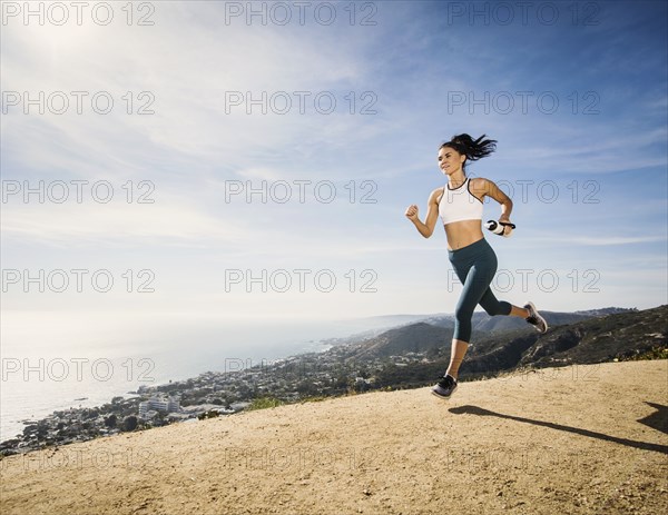 Woman jogging on mountain with water bottle