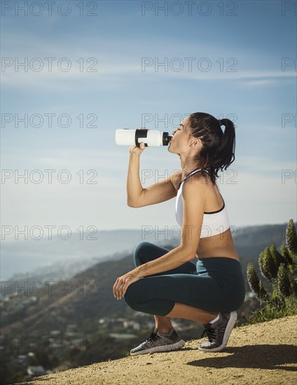 Woman in sportswear drinking water from bottle