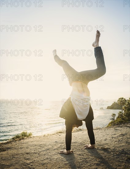 Man doing handstand on beach