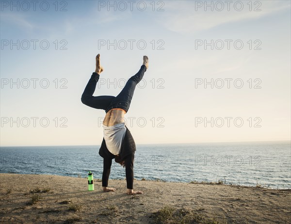 Man doing handstand on beach