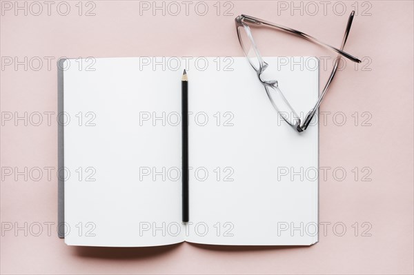 Pencil and glasses on open notebook