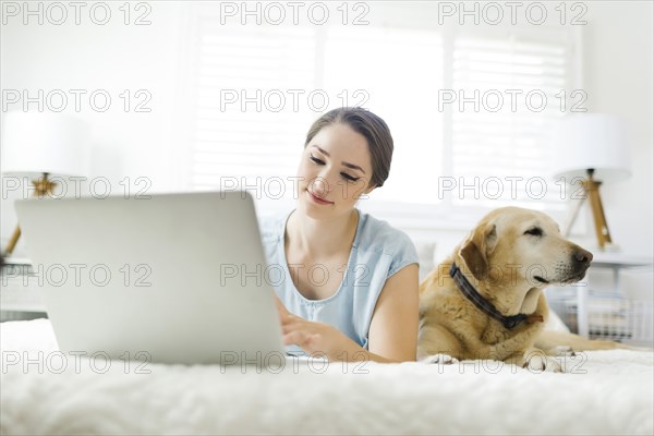 Woman using laptop with dog