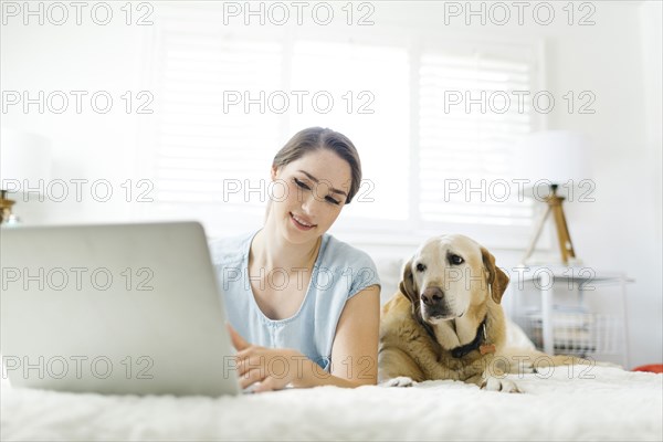 Woman using laptop with dog