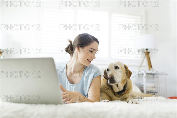 Woman using laptop with dog