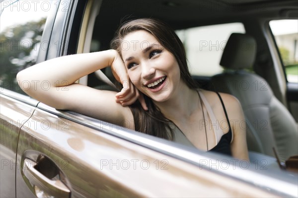 Smiling young woman sitting in car