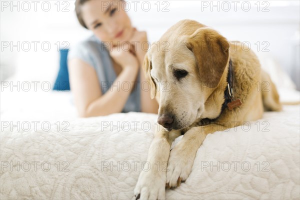 Woman lying on bed with dog